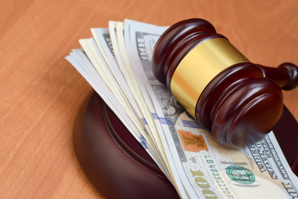 Judge gavel and money on brown wooden table