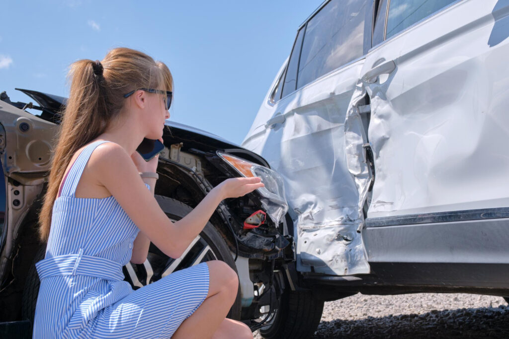 Woman driver talking on mobile phone after car accident