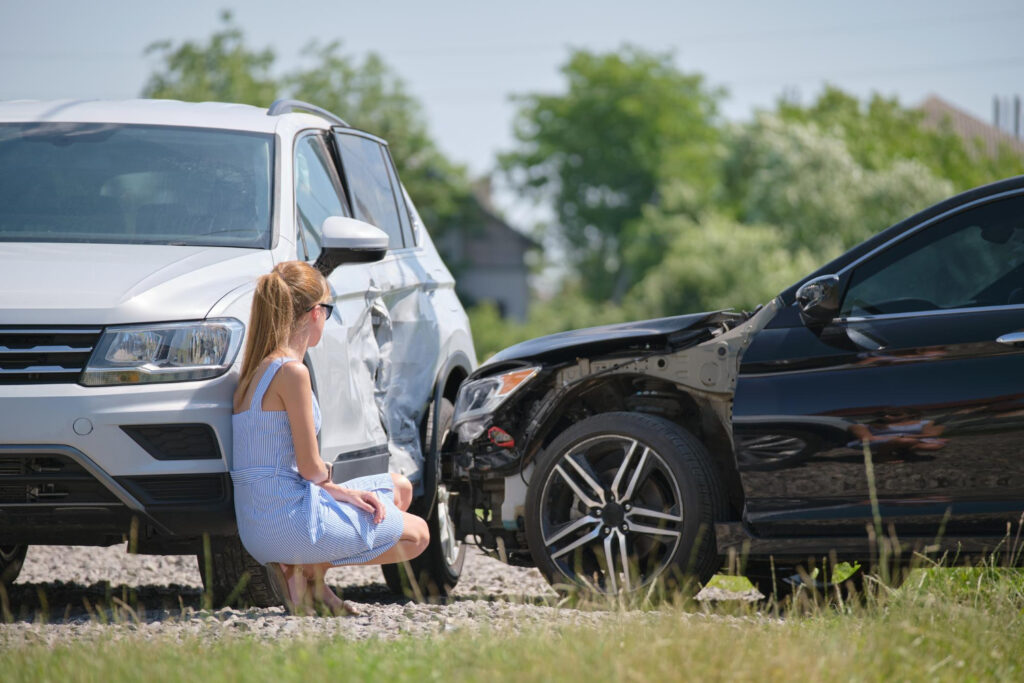 Driver sitting on street side after car accident