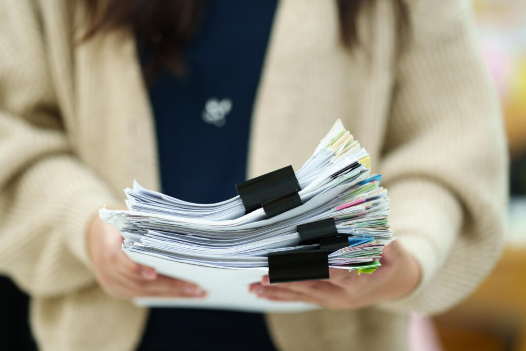 Woman holding a pile of paperwork