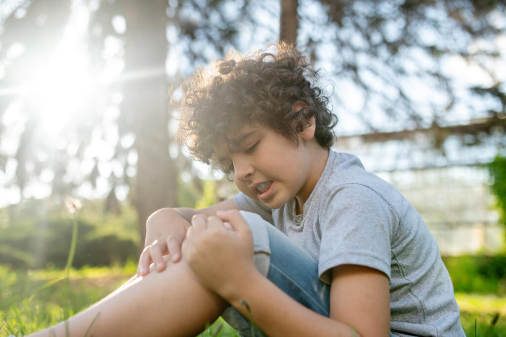 Boy examining his damaged knee