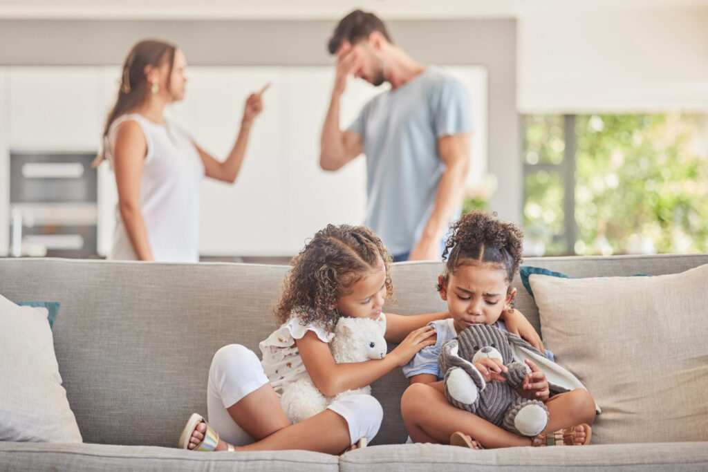 Couple fight and divorce with sad children on sofa