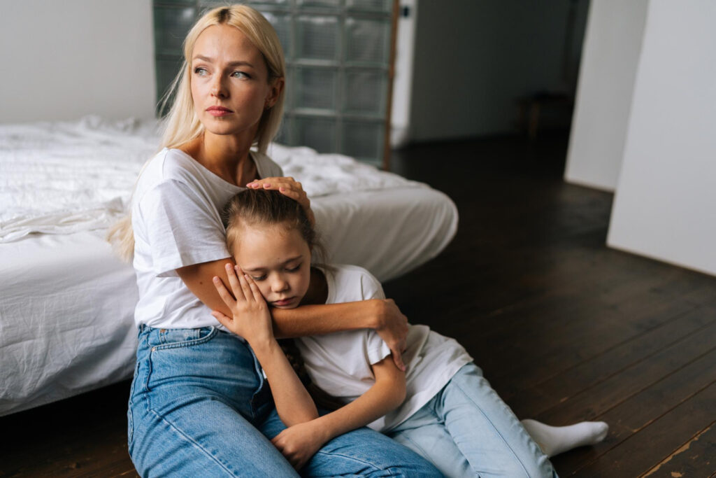 Upset little girl and caring mother