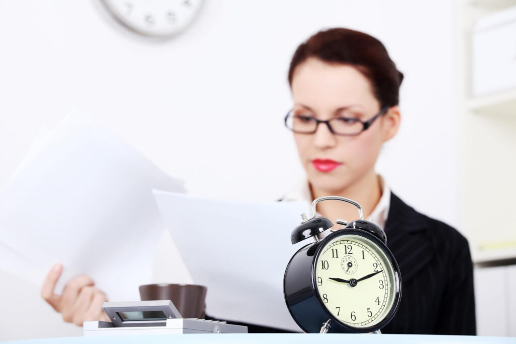 Alarm clock with woman working at desk