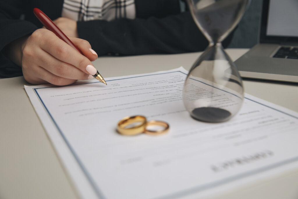 Hands of wife signing decree of divorce